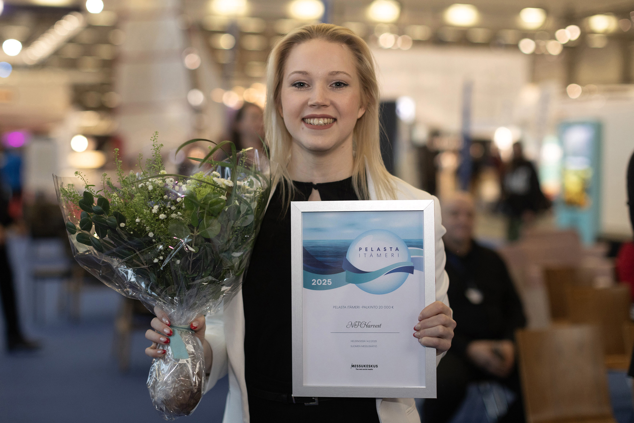 Sara Ikonen holding the Save the Baltic Sea 2025 award certificate and flowers